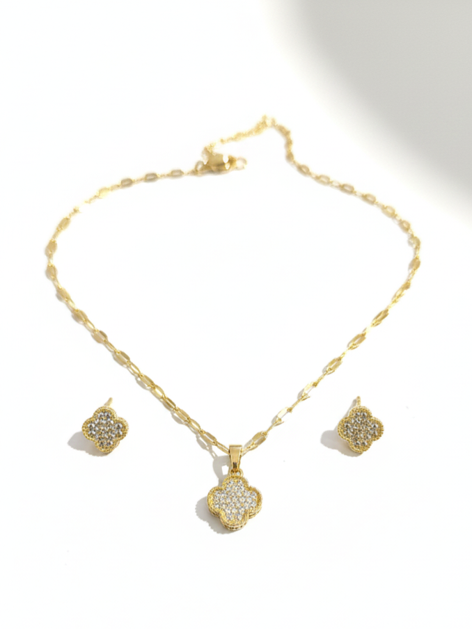 Gold necklace and earrings set on a white background