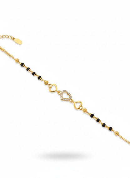 Gold bracelet with heart-shaped charms and black beads 