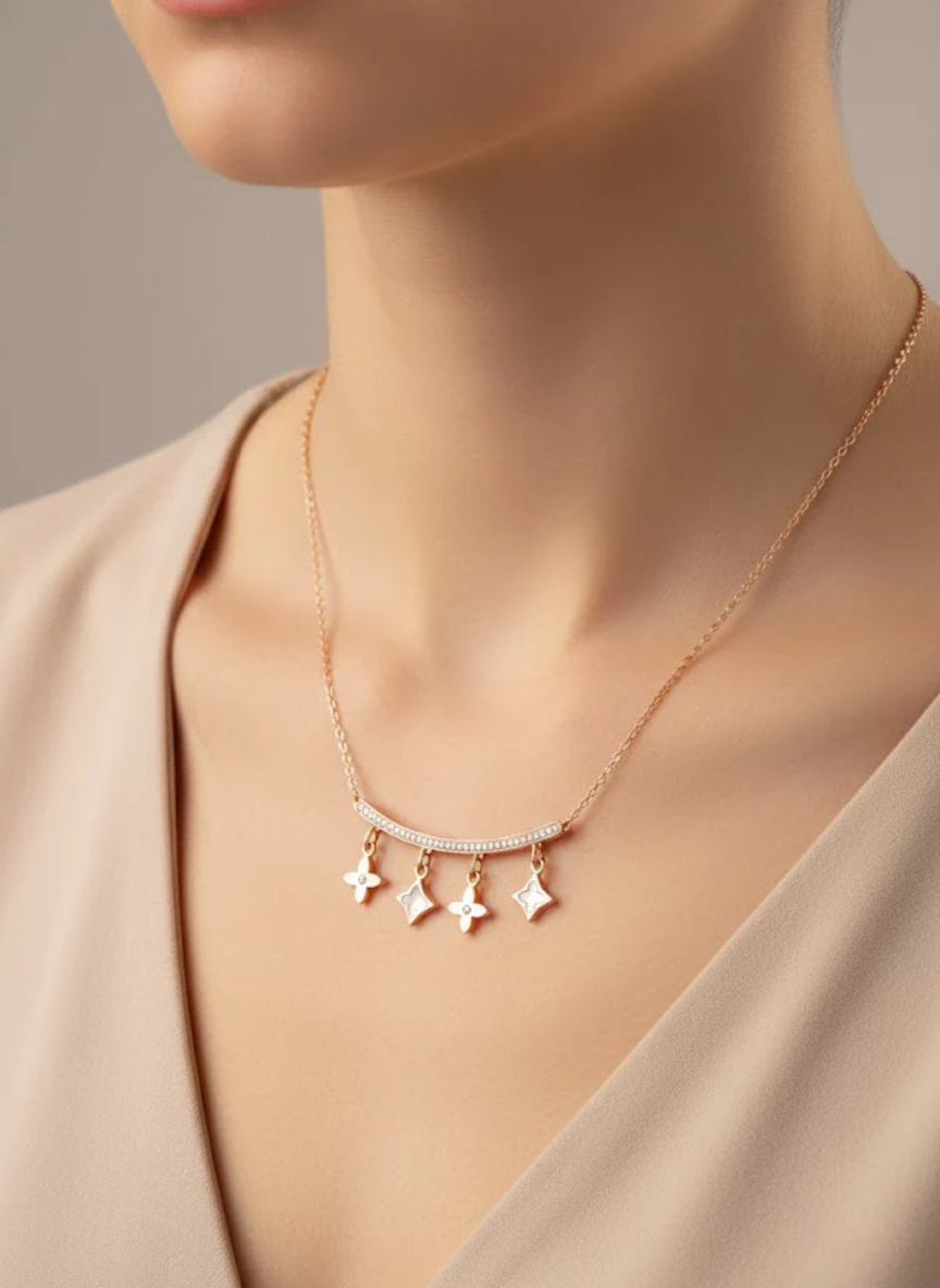 Necklace with star-shaped pendants on a mannequin wearing a beige top.